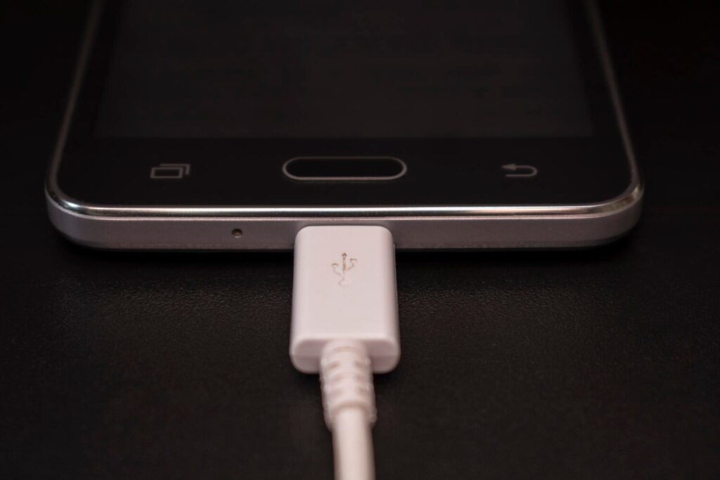 black smartphone black background with white cable 655097 360