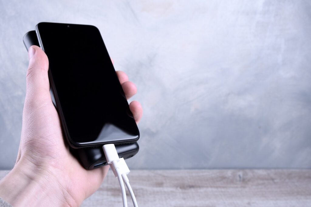 phone charging powerbank charges smartphone cellphone with energy bank depth field power bank man holds handss 150455 694